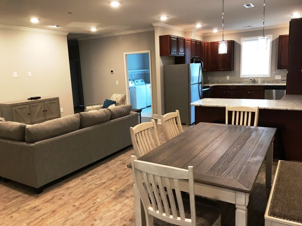 Main room with dining table, couches and kitchen